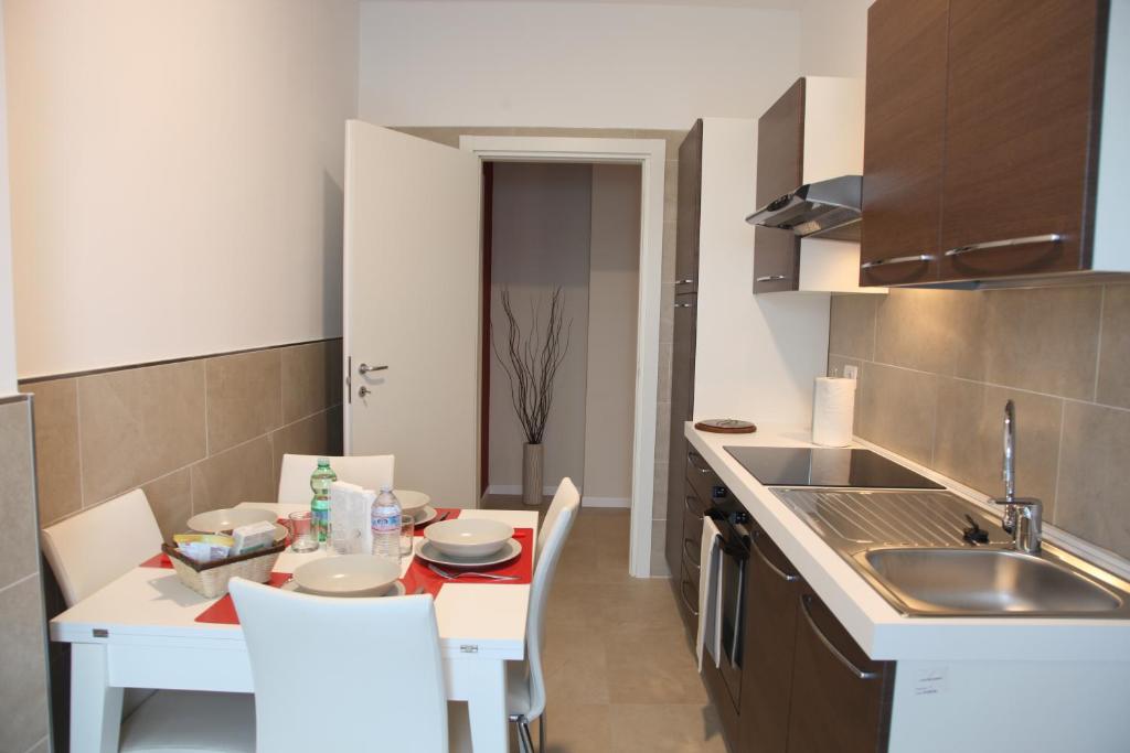 kuchnia ze stołem, krzesłami i zlewem w obiekcie Residenze Italia w mieście Sesto San Giovanni