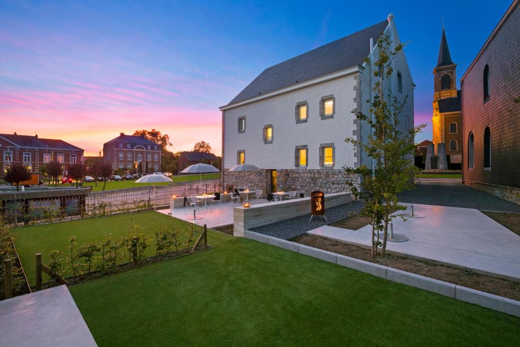 a building with a grass yard next to a church at B&B Opus35 in Montzen