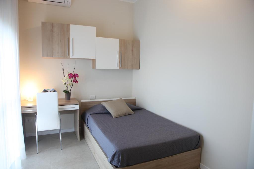 niewielka sypialnia z łóżkiem i biurkiem w obiekcie Residenze Italia w mieście Sesto San Giovanni