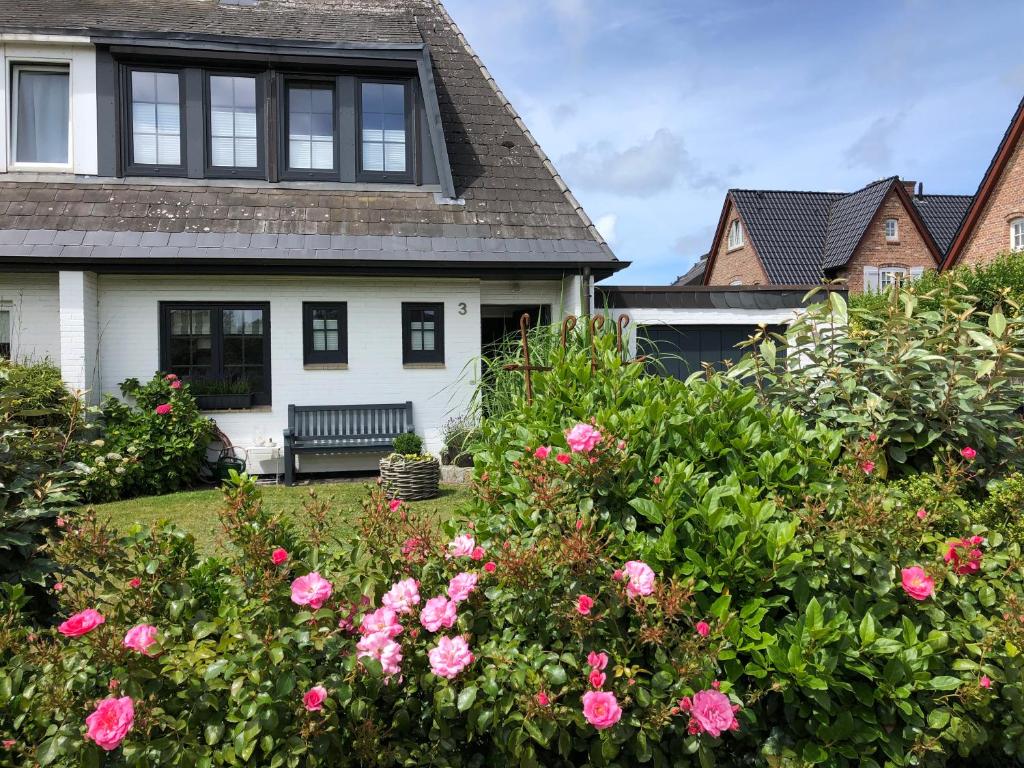 ein Haus mit rosa Blumen im Hof in der Unterkunft Ferienhaus Berg in Sylt