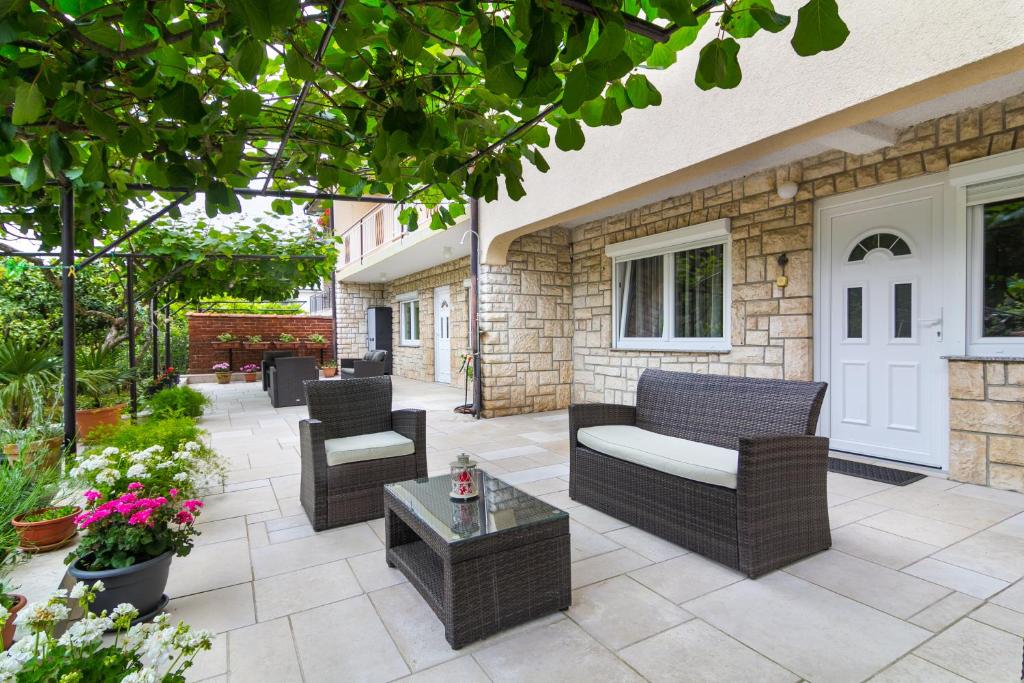 a patio with chairs and a couch and a table at Apartments Nicole in Pula