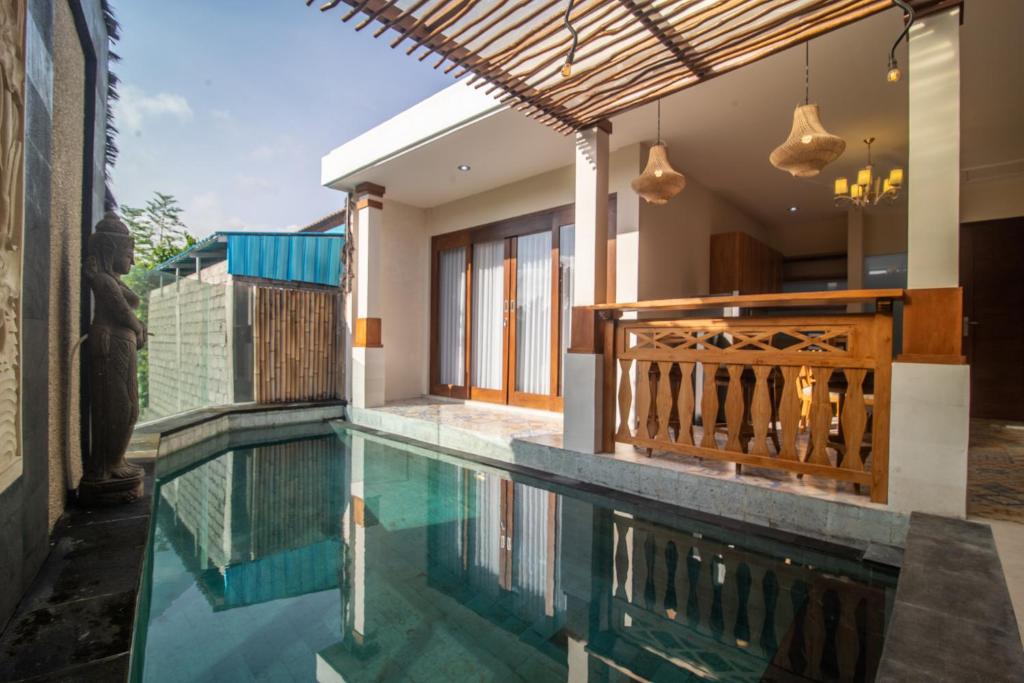 a house with a swimming pool and a balcony at Villa Dewi 3 in Ubud