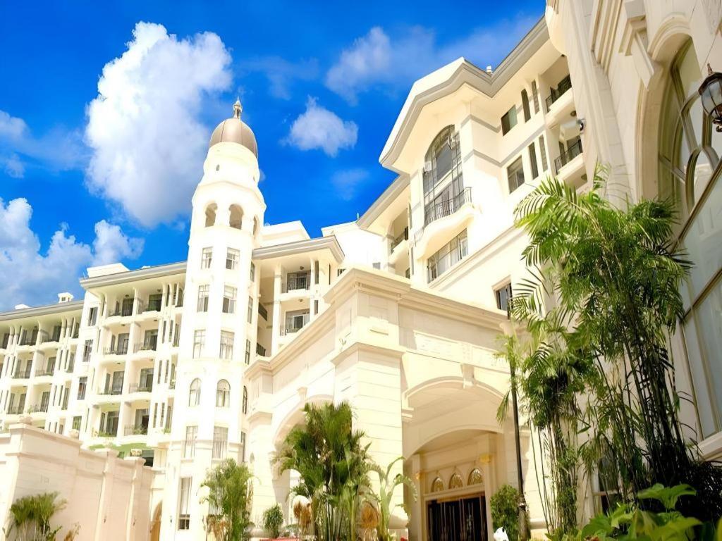 a large white building with a clock tower at Country Garden Phoenix Hotel Huangshan in Huangshan