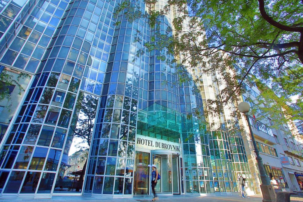 a tall glass building with people standing in front of it at Hotel Dubrovnik in Zagreb