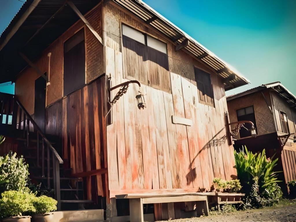 ein Holzgebäude mit einer Seitentür in der Unterkunft Jidapa Resort in Ban Khlong Takhian