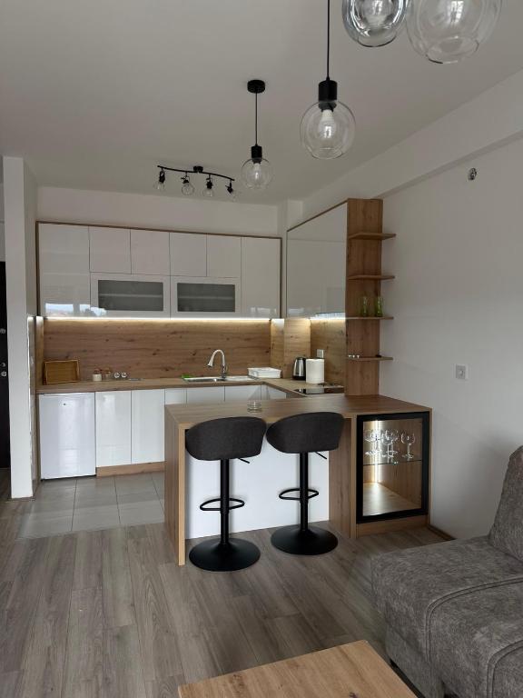 a kitchen with two bar stools next to a counter at apartmanjagodinaana in Jagodina