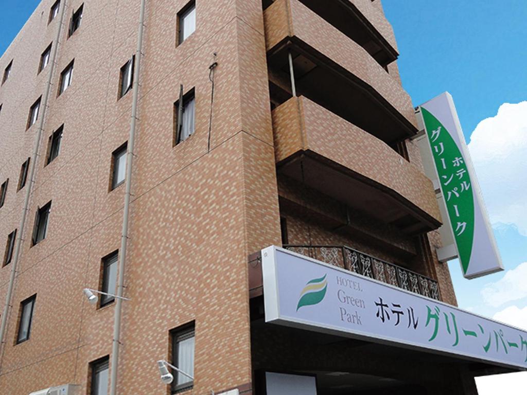 un edificio de ladrillo con un cartel delante en Hotel Green Park en Sendai