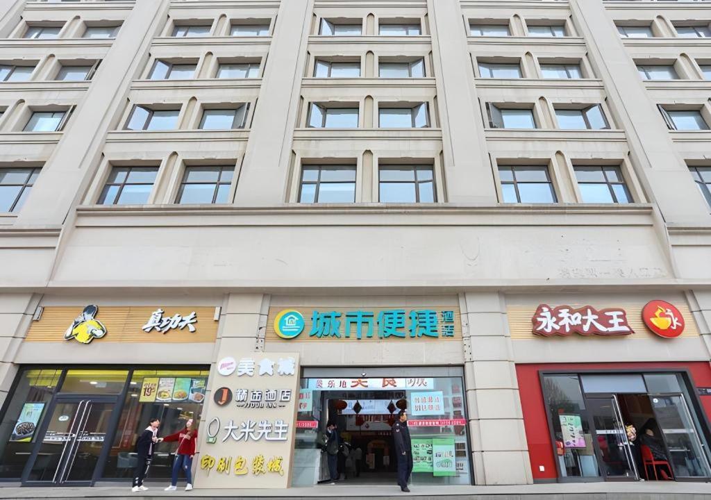 a large building with people standing outside of it at City Comfort Inn Wuhan Hankou Railway Station West Square in Wuhan