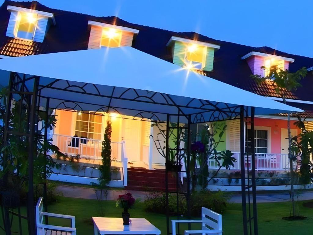 un parapluie bleu devant une maison la nuit dans l'établissement Chiangkhan Gallery Resort, à Chiang Khan