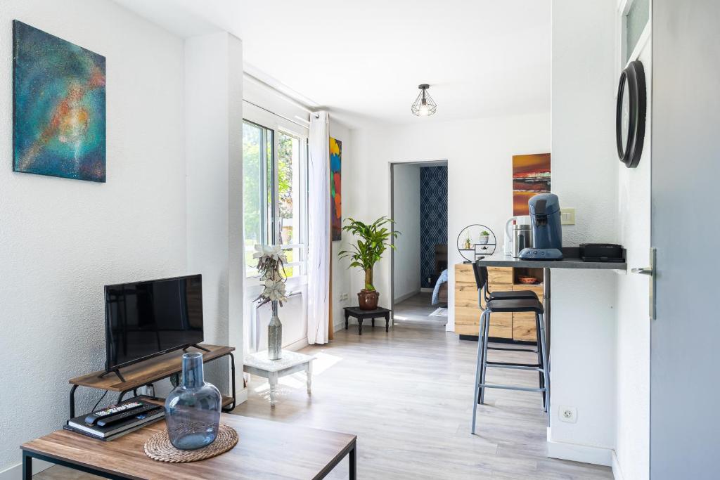 un salon avec une télévision et une table dans l'établissement Chazi, à Toulouse