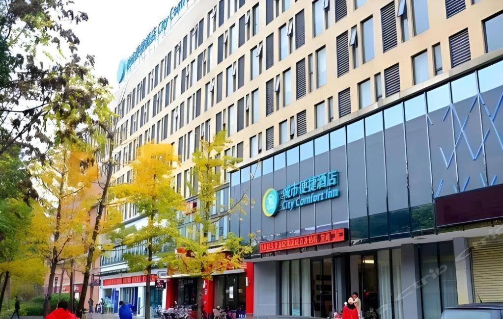 a building on a street with people walking in front of it at City Comfort Inn Wuhan Baibuting in Wuhan