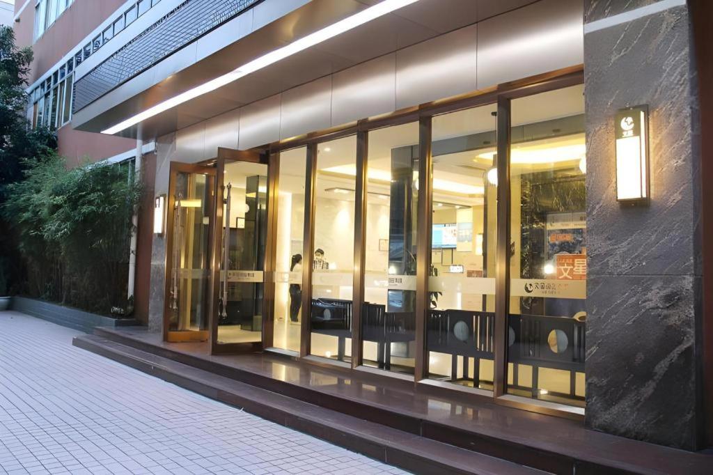 a store front with glass doors on a building at Wenxing Hotel Guangzhou Gangding Metro Station Branch in Guangzhou