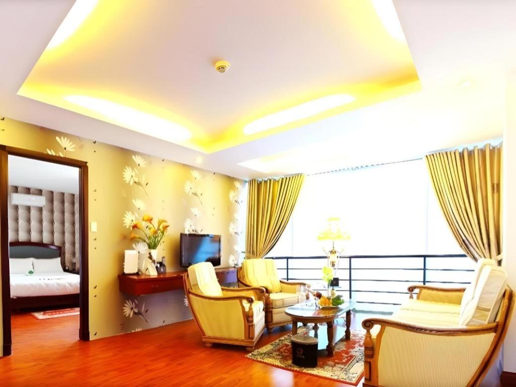 1 dormitorio y sala de estar con muebles de color amarillo. en Universe Hotel, en Ho Chi Minh