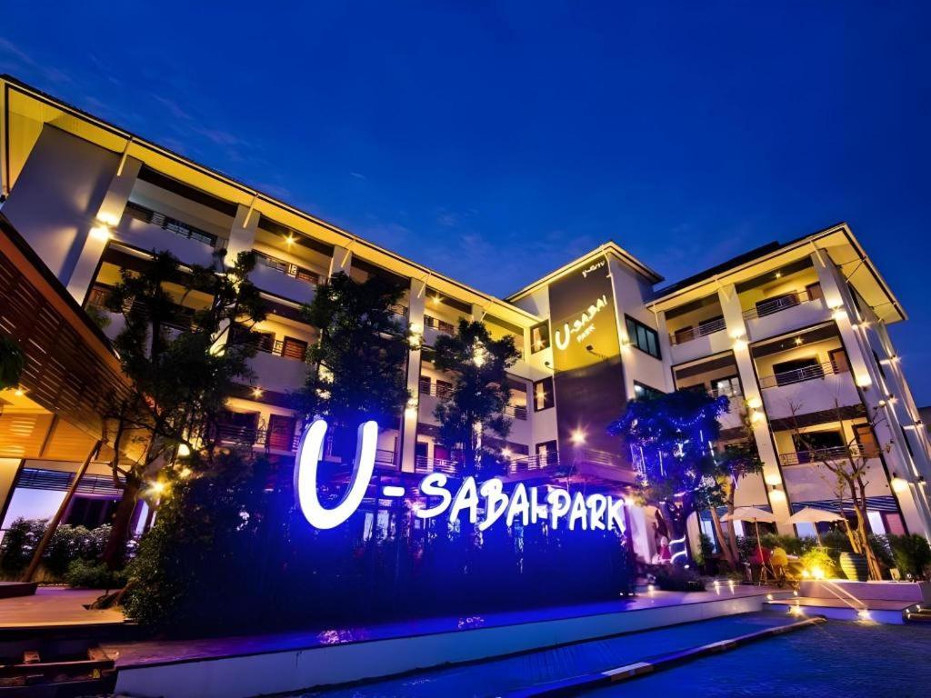 un grande edificio con un cartello sul lato di U-Sabai Park Resort a Nakhon Ratchasima