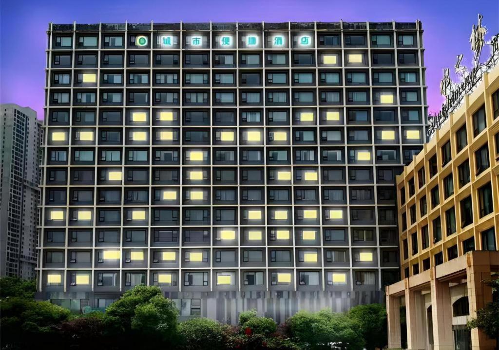 wysoki budynek z wieloma oknami w nocy w obiekcie City Comfort Inn Wuhan Huangpu w mieście Wuhan