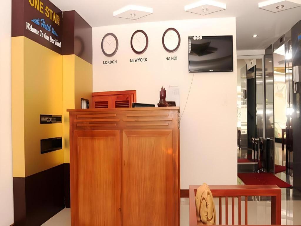 ダナンにあるOne Star Hotel Danangの木製のドアと壁に時計が掛かっている部屋