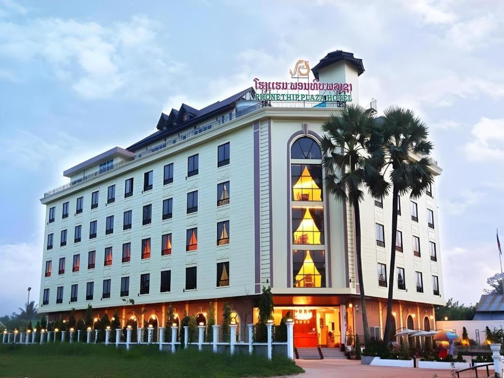 a large white building with palm trees in front of it at Phonethip Plaza Hotel in Vientiane