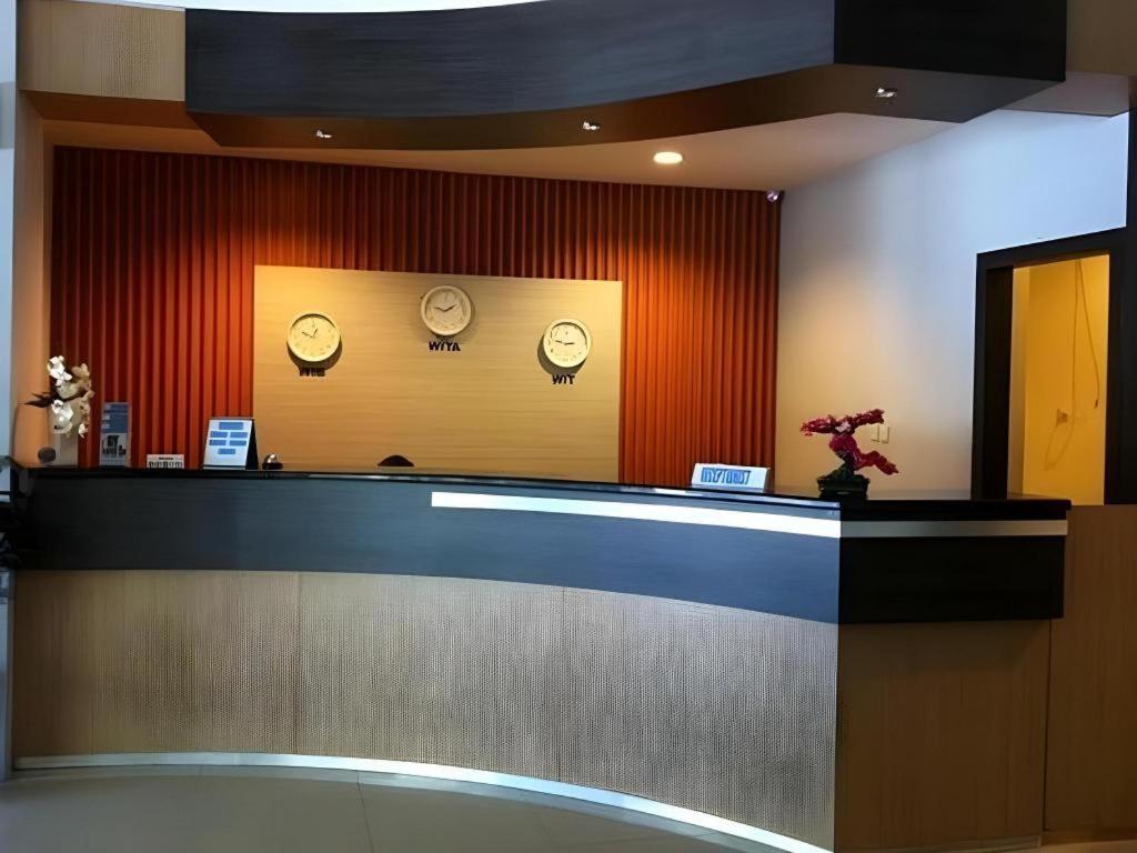 a lobby with clocks on the wall and a counter at Hotel Benua in Kendari
