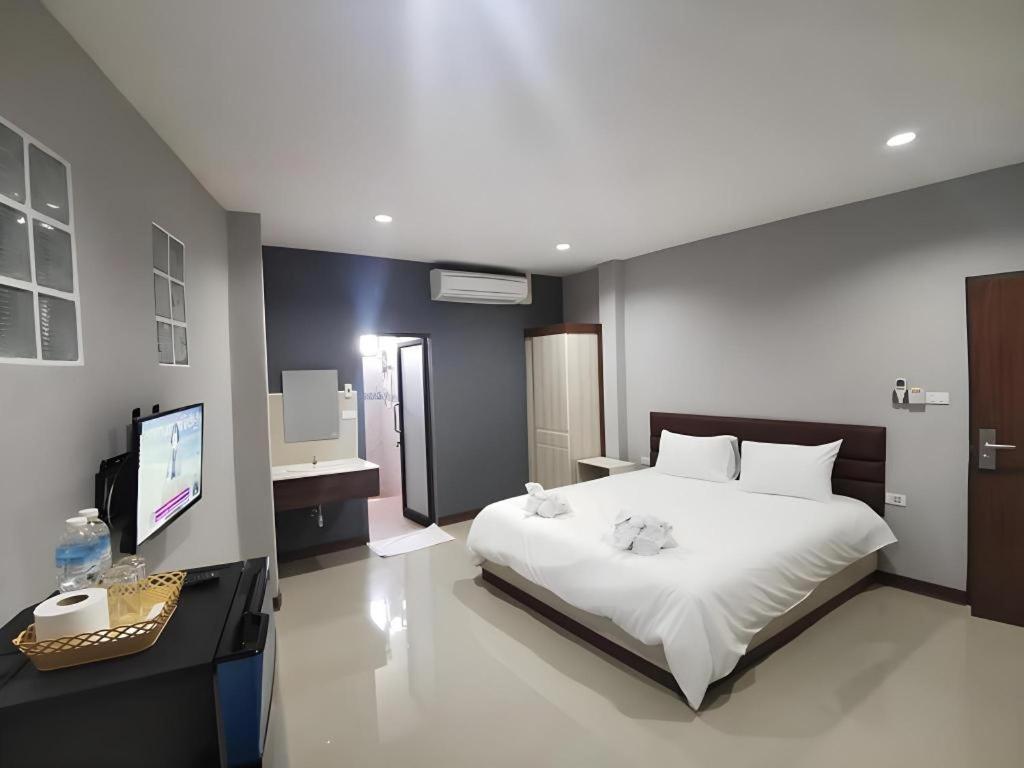 a bedroom with a bed and a desk and a television at Poompimaan House in Udon Thani
