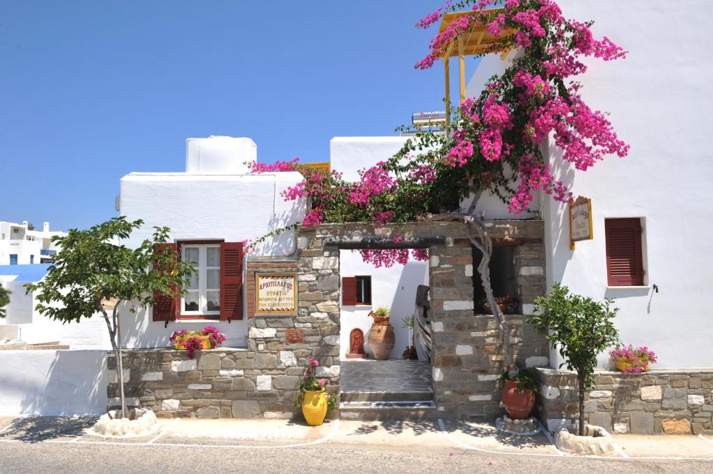 un edificio con dei fiori sul lato di Archipelagos Studios a Naoussa