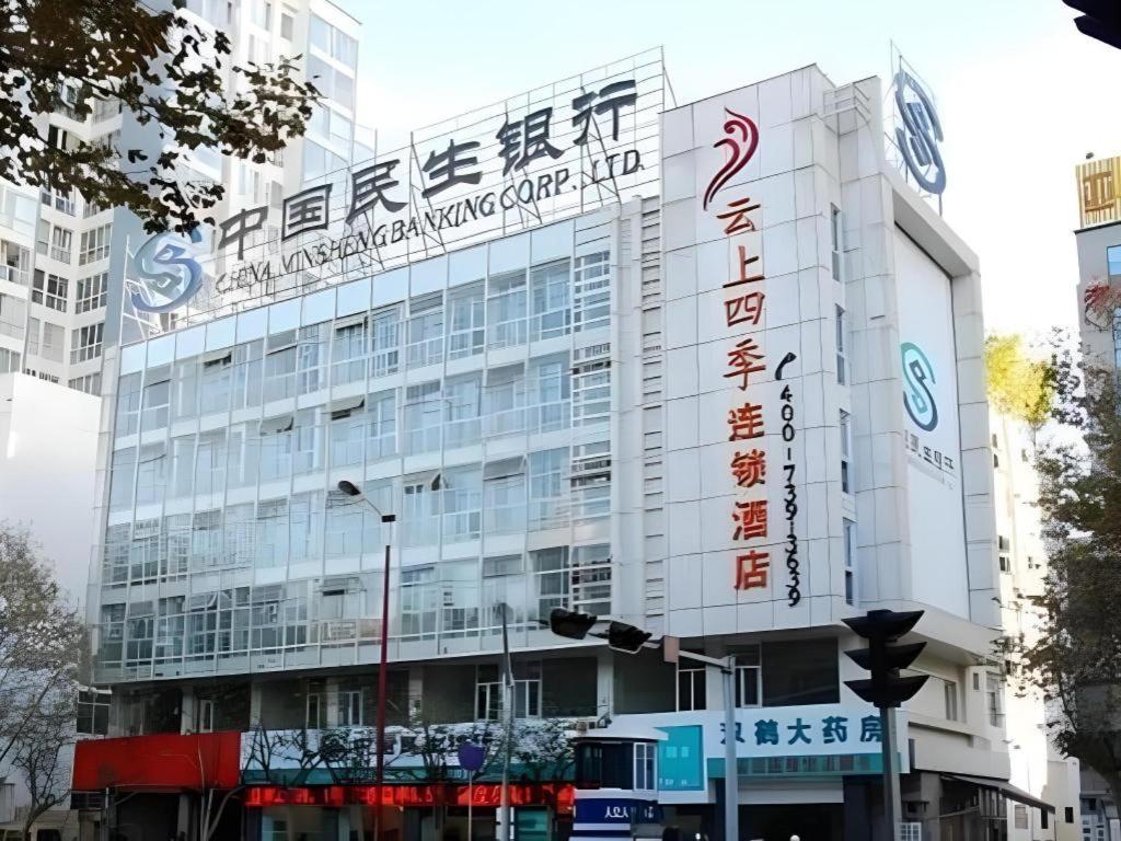 a building with a sign on the side of it at Fairyland Hotel Kunming Tuodong Branch in Kunming