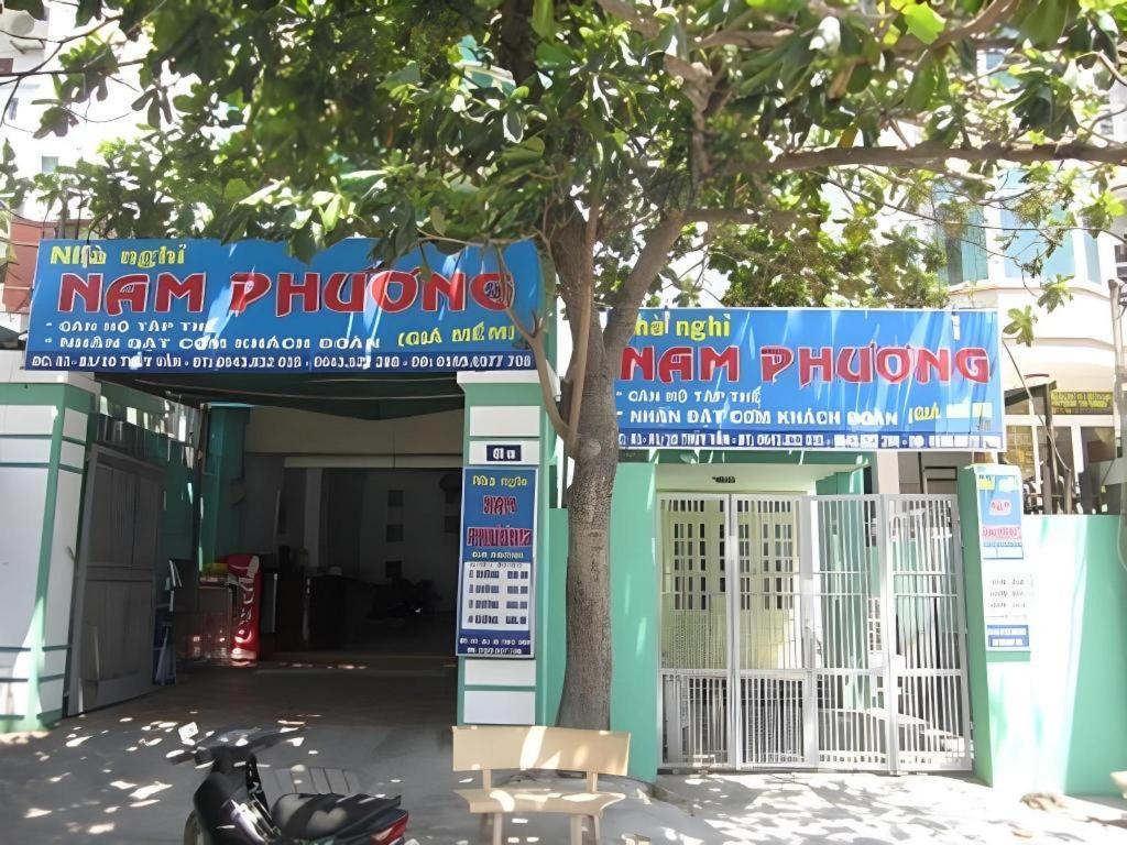 a motorcycle parked in front of a building with a tree at Nam Phuong Hostel 2 in Vung Tau