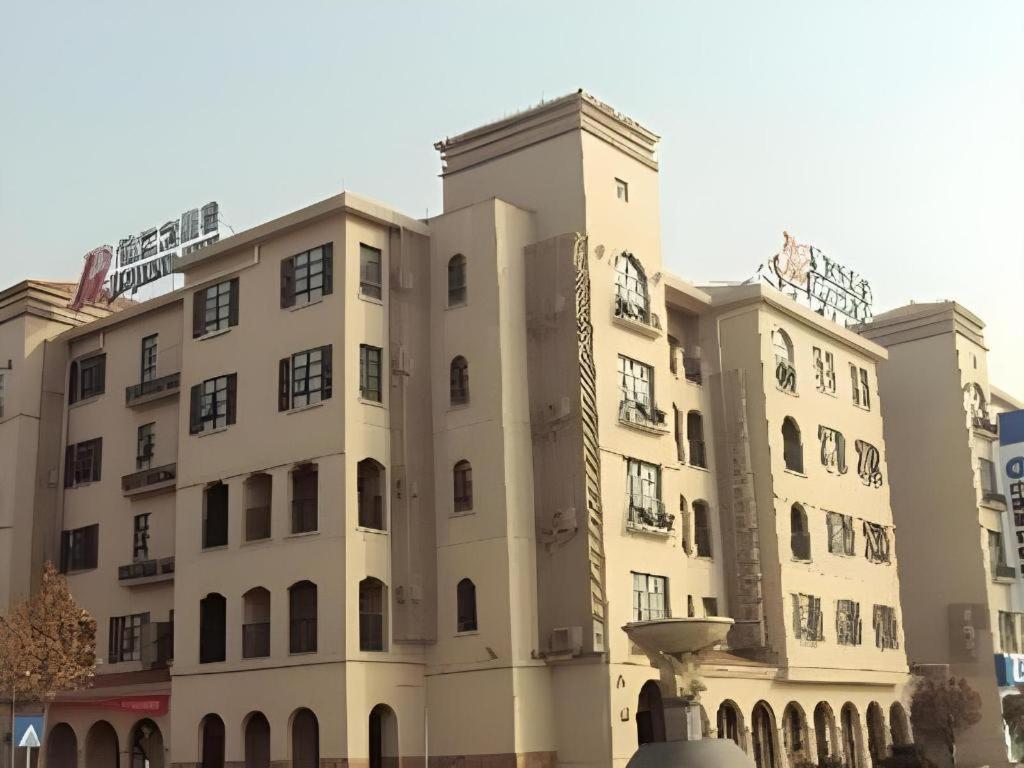 a large building with a fountain in front of it at JinJiang Inn Baoji Administra Tion Center in Baoji