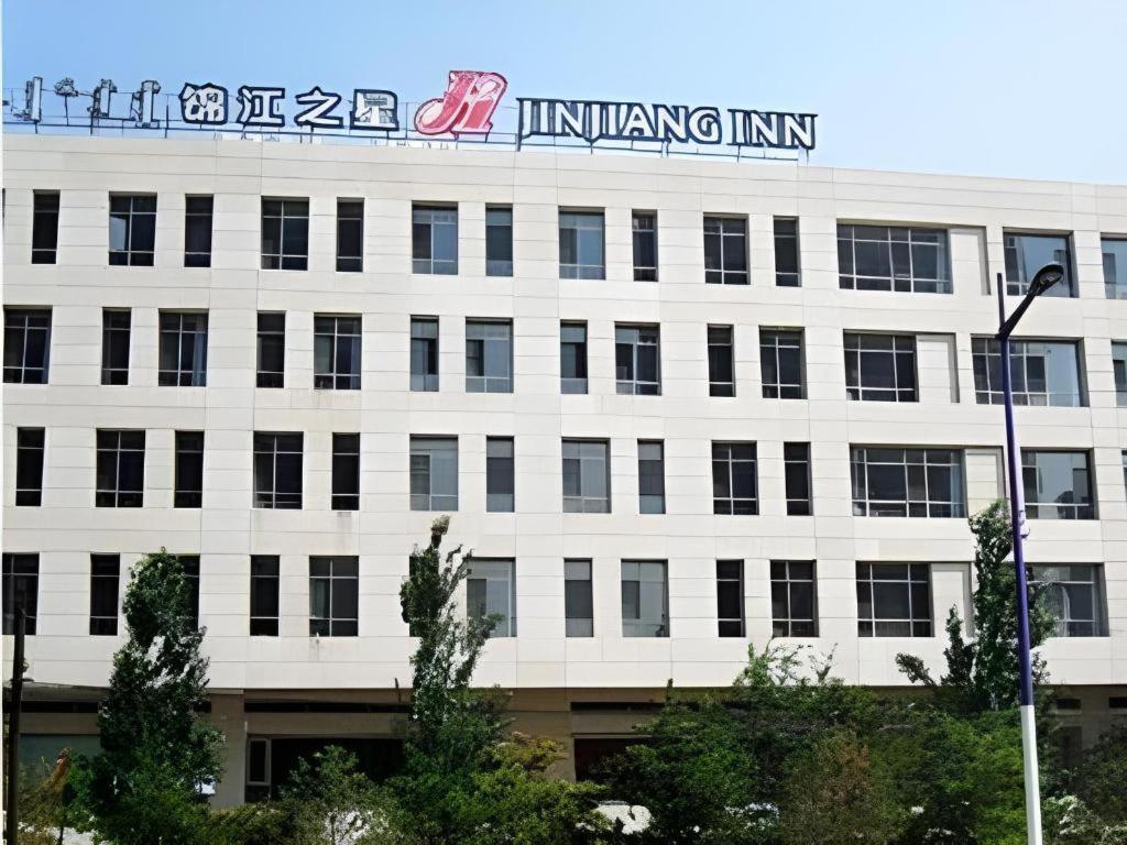 a building with a sign on top of it at Jinjiang Inn Baotou Saihan Tara Park Youyi Street in Baotou