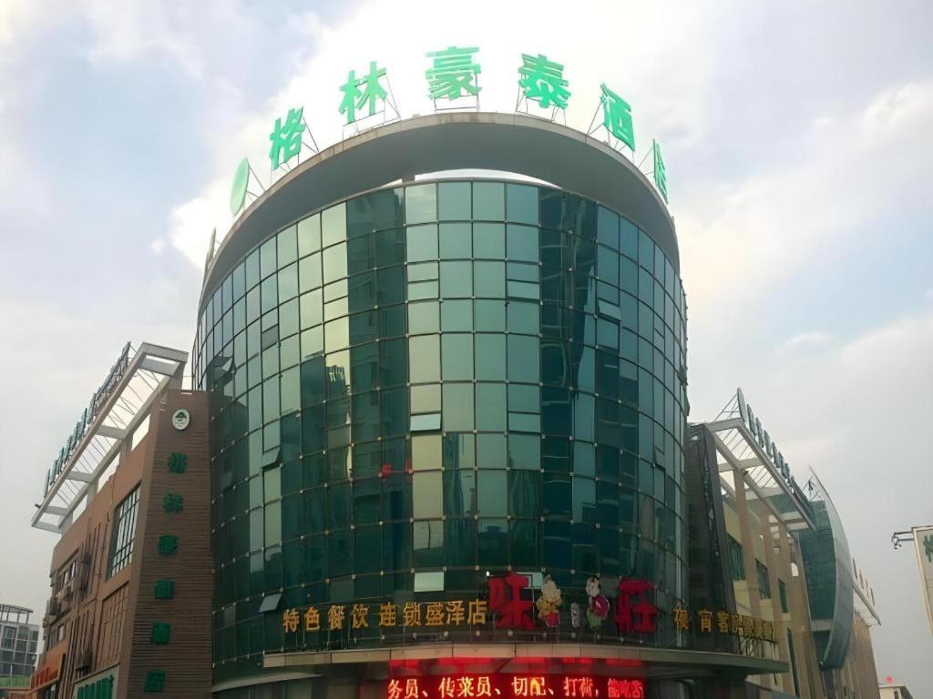a glass building with chinese writing on top of it at GreenTree Inn Suzhou Shengze Hotel in Suzhou