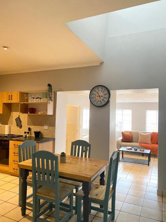 a kitchen with a table and chairs and a clock on the wall at Nunu's Self Catering Apartment in Paarl