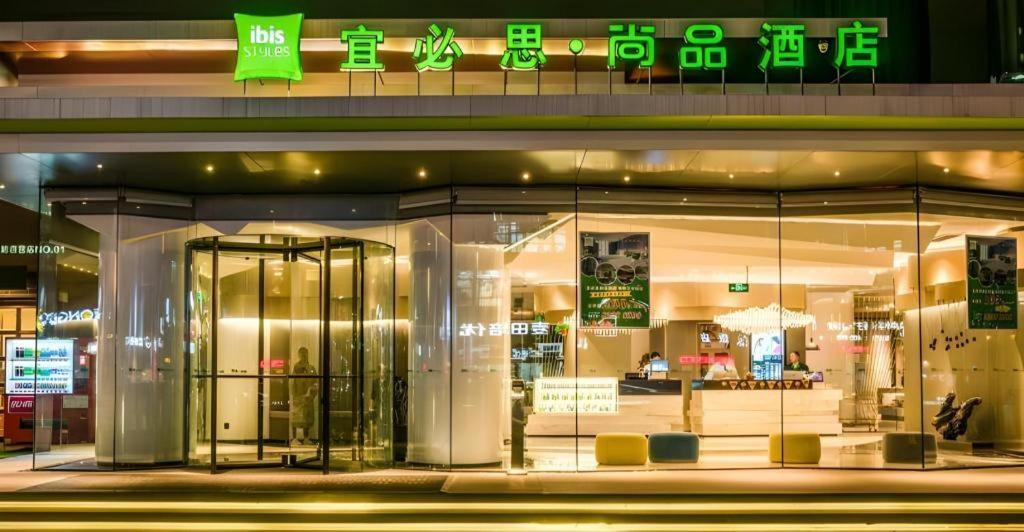 a store front of a store with green signs on it at ibis Styles Yangzhou Baixiang Rd Hotel in Yangzhou