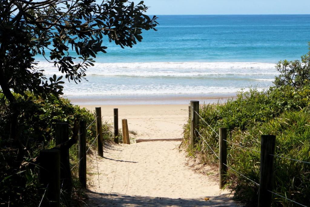 un camino a la playa con el océano en el fondo en Surf Beach Motel Coffs, en Coffs Harbour