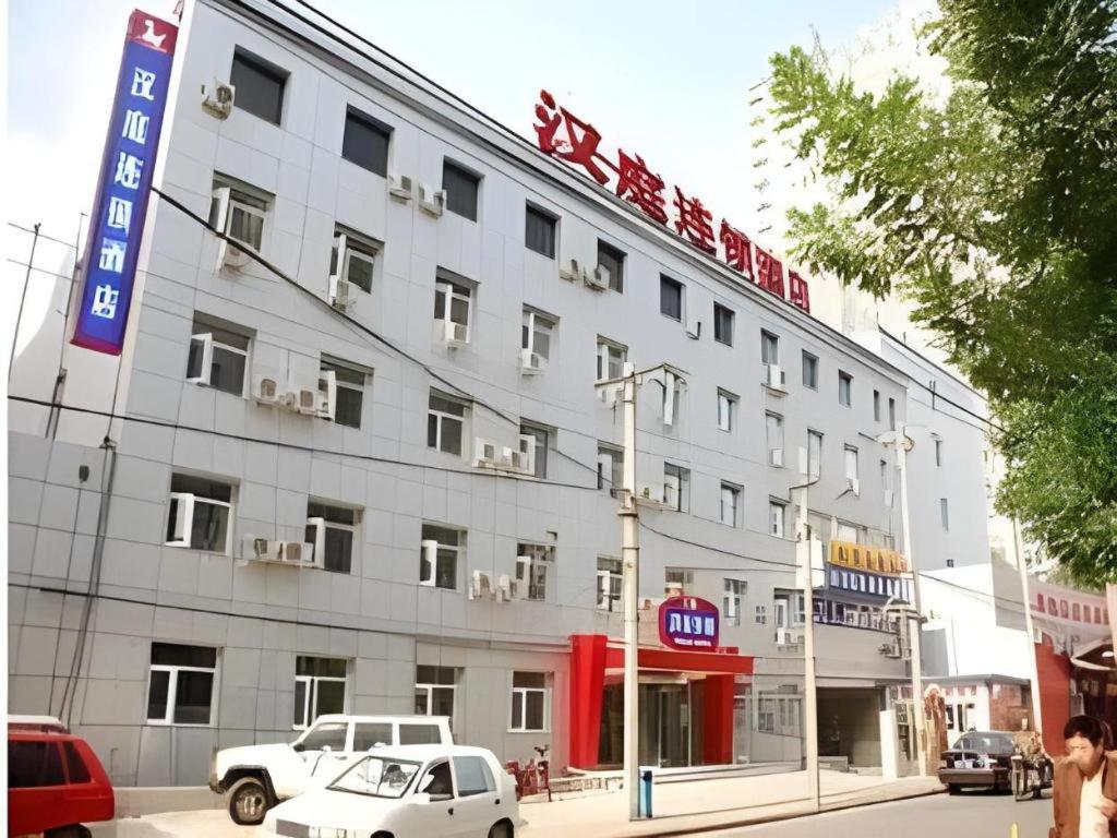 a large building with cars parked in front of it at Hanting Hotel Beijing National Stadium Branch in Beijing