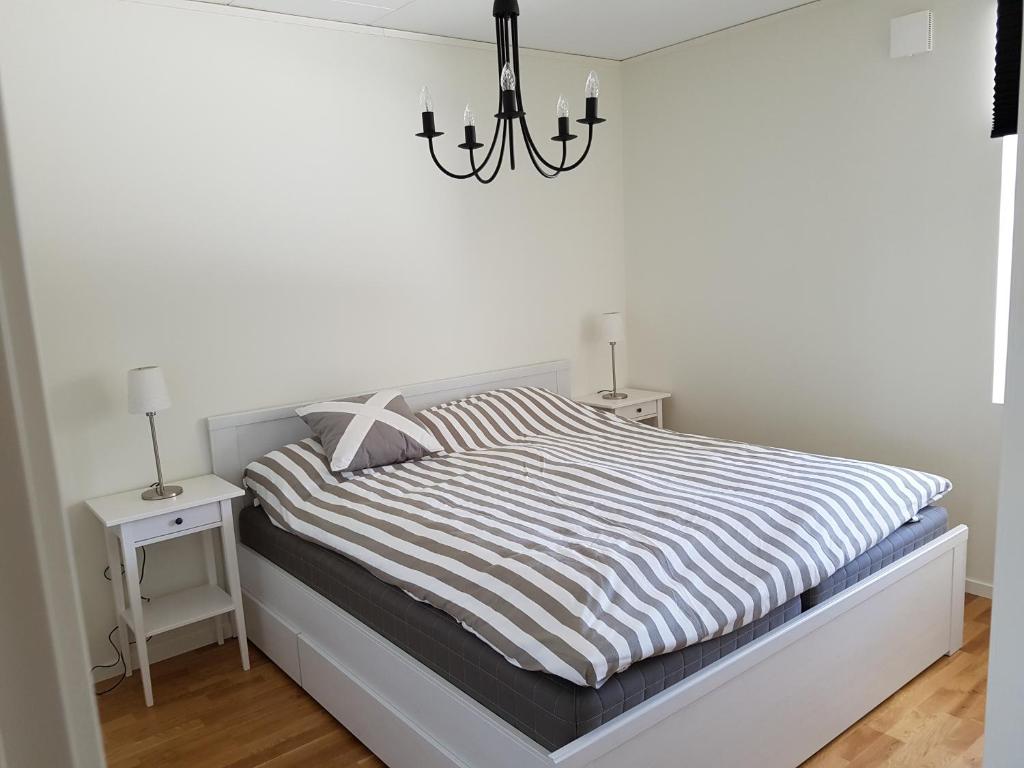 a white bedroom with a bed and a chandelier at Fjällbacka in Fjällbacka