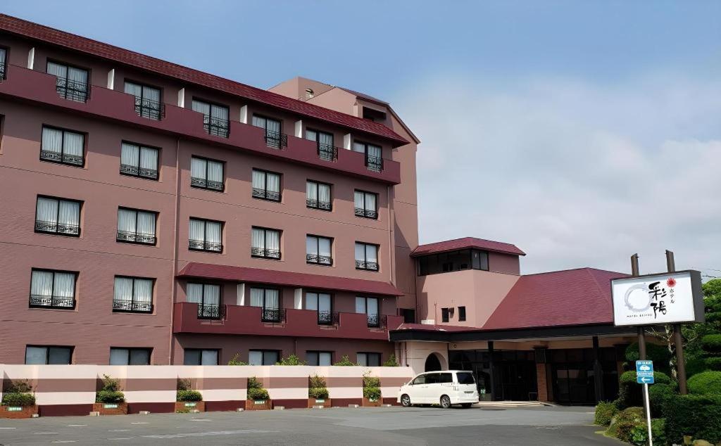 a large red building with a white car parked in front of it at Hotel Saiyou WAKIGAWA in Hirado