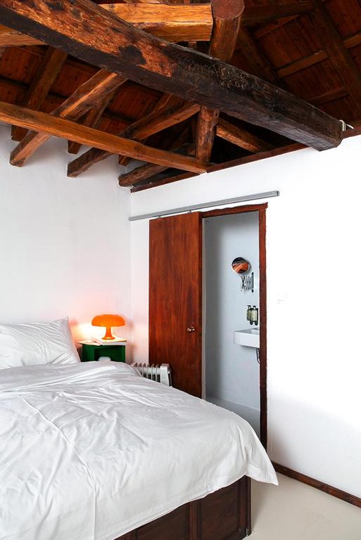 a bedroom with a white bed and a wooden ceiling at The Pelion Manifesto 2 in Agios Georgios Nilias