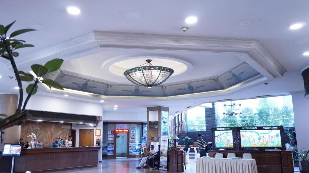 a lobby with a chandelier hanging from a ceiling at Kedaton Hotel in Bandung