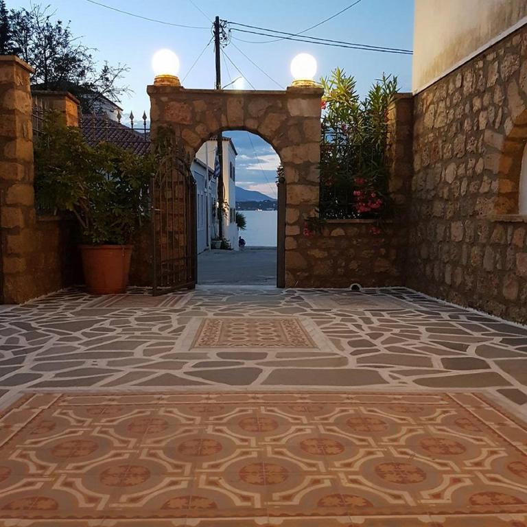 an entrance to a building with an arch and a tile floor at Kastro Hotel in Spetses