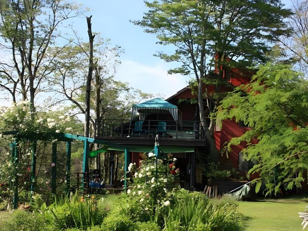 a house with a deck in the middle of a yard at Country Inn Canadian House in Myoko