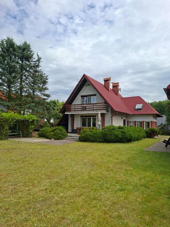 a house with a red roof on a yard at Willa na Kaszubach z wlasna linia brzegowa nad jeziorem 4 sypialnie ,ryby,grzyby in Zgorzałe