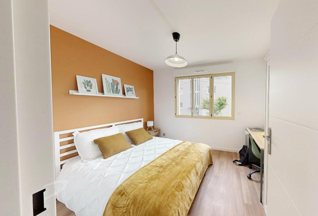 une chambre avec un grand lit dans une pièce dans l'établissement Les Tilleuls I, à Villeurbanne