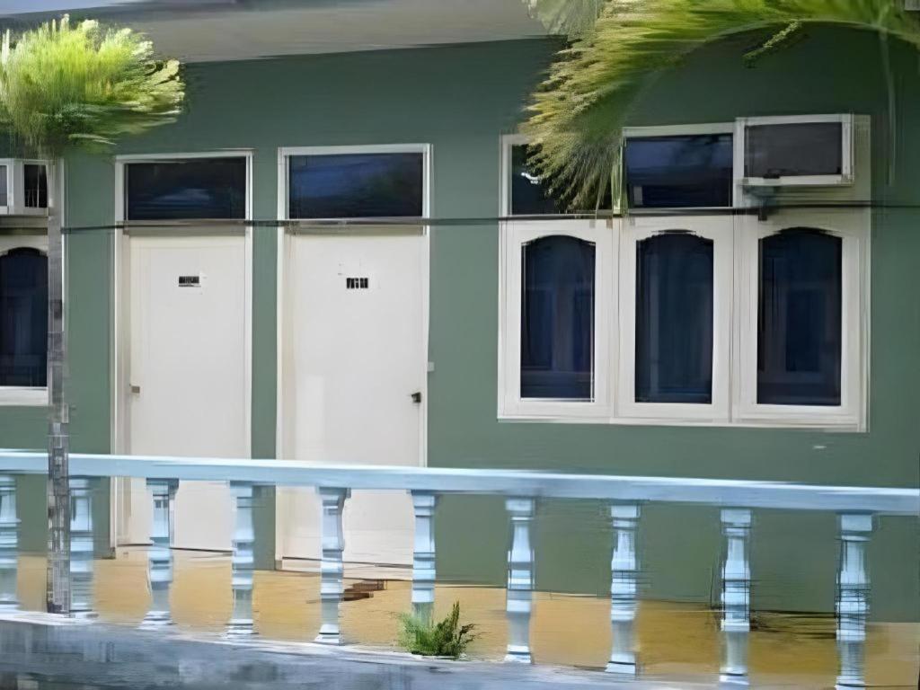 ein grünes Gebäude mit weißen Türen und Fenstern in der Unterkunft Mawanza Hotel Langkawi in Langkawi Islands