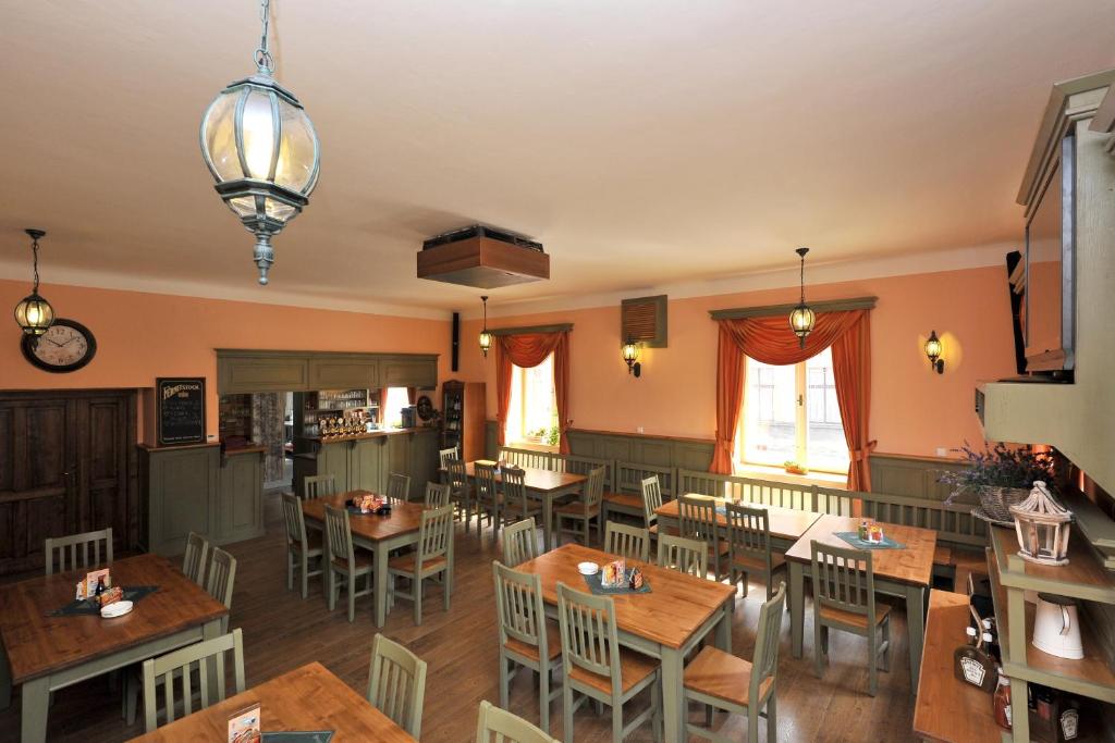 Hotel Kácov في Kácov: غرفة طعام مع طاولات وكراسي خشبية