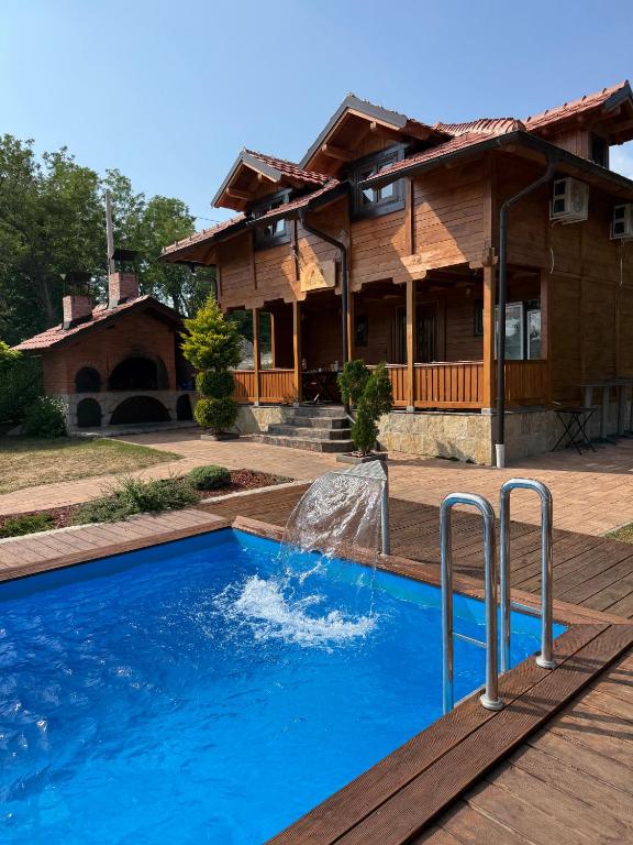a swimming pool in front of a house at Vila Rudnicka Idila in Gornji Milanovac