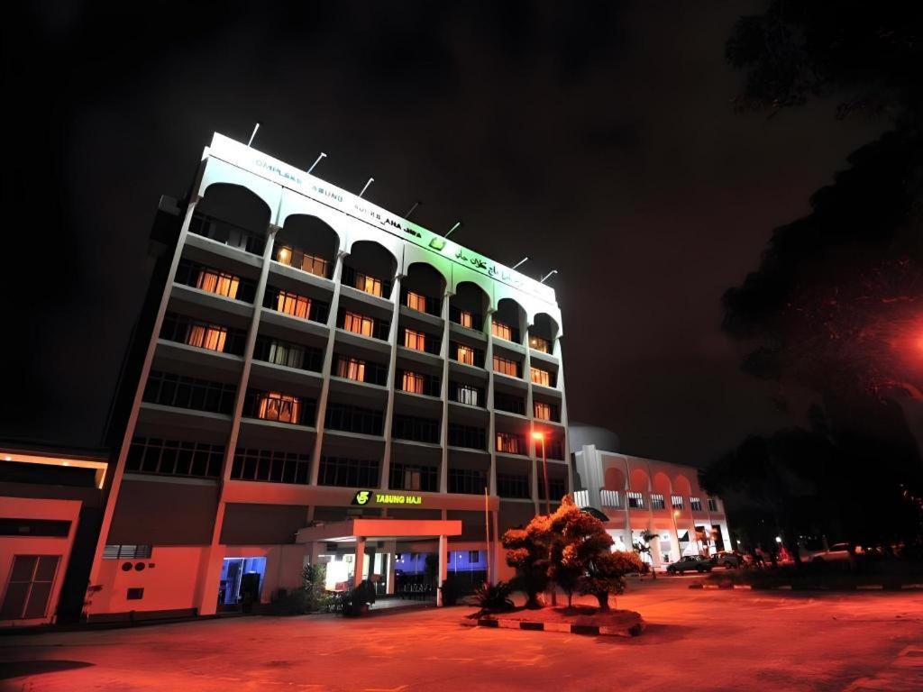 a hotel building with a statue in front of it at night at TH Hotel - Kelana Jaya in Sungai Way