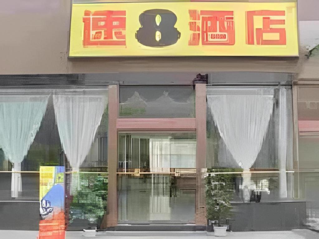 a store front with white curtains in the window at Super 8 Hotel Xi'an Dayan Tower Heping Gate Metro Station in Xi'an