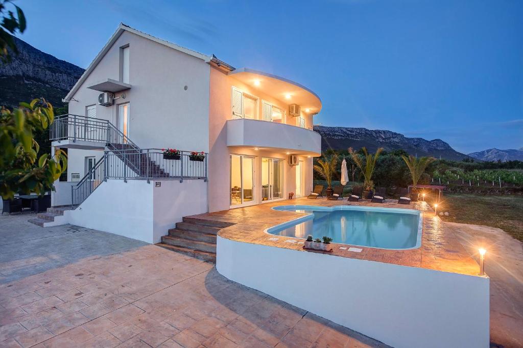 una casa con una piscina di fronte di Villa Pia Split a Kaštela (Castelli)