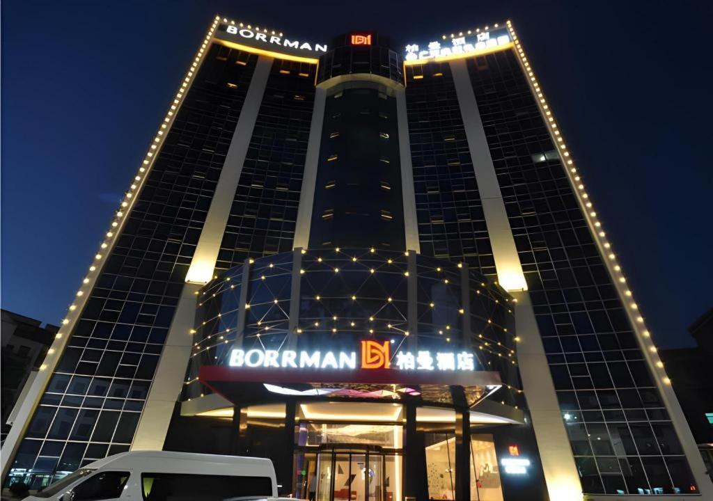 ein hohes Gebäude mit einem Domiman-Schild davor in der Unterkunft Borrman Hotel Hechi Bama Central Cultural Plaza in Bama