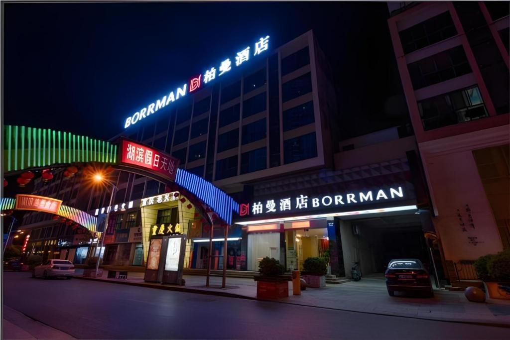 un edificio con insegne al neon di notte di Borrman Hotel Wuxi Hubin Business Street a Wuxi
