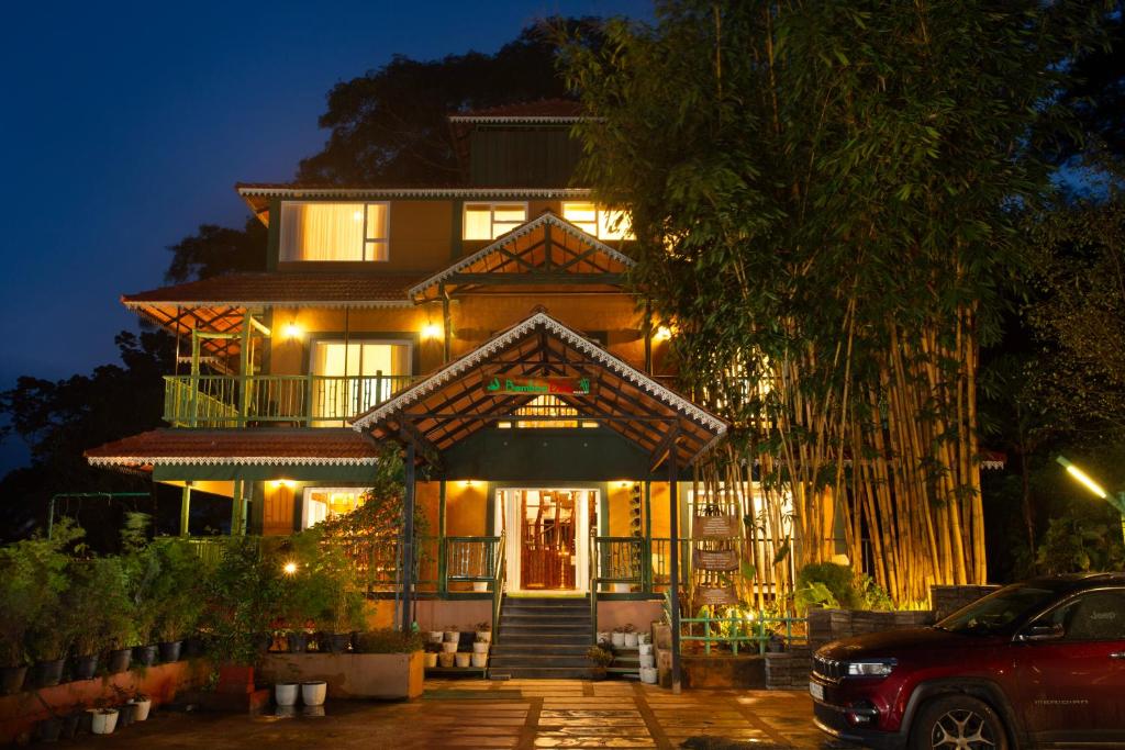 a large house with a lit up facade at night at Bamboo Dale Resort & Spa Munnar by Stride in Munnar